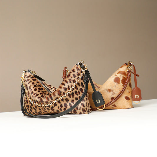 Two handbags, crossbody bags, Zeste Jr, Danilos, hair-on leather, with leopard print and the other with brown spotted pattern, on a beige background.