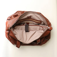 Open brown leather duffle bag with zippered compartment.