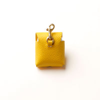 Back view of yellow Airpod Case Santi Jr. leather with snap closure