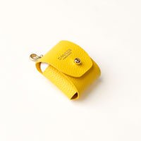 Side view of yellow Airpod Case Santi Jr. leather with snap closure