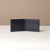 Black leather wallet open on a beige background