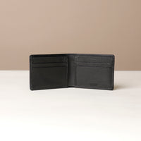 Black leather wallet open on a beige background