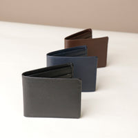 Four leather wallets in black, blue, and brown on a white surface with a beige background.