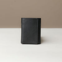 A closed trifold wallet in black color, made from pebbled leather, displayed against a neutral background.