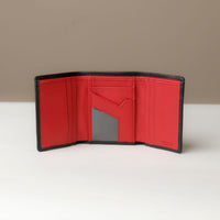 A open trifold wallet in black and red color, made from pebbled leather with nappa leather interior, with 6 slots for cards and a long comparment for cash, displayed against a neutral background.