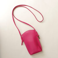 Pink crossbody bag on a light beige background
