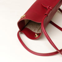 Red handbag with gold accents on a white background