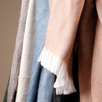 Close-up of various textured scarves in different colors.