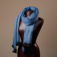 Blue scarf on a mannequin against a brown background