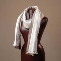 Mannequin wearing a scarf with a gradient of colors on a brown background