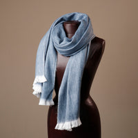 Blue scarf with white edges on a mannequin against a brown background