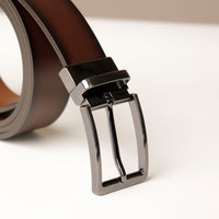 Close‑up of gradient finish on dark brown leather belt and buckle