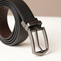 Close‑up of pebble texture on black leather belt and buckle detail