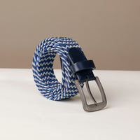 A blue elastic belt with a metallic buckle on a white surface.