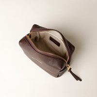 Top view of open Leather toiletry bag in brown color, displayed against a neutral background.