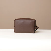 Back view of Leather toiletry bag in brown color, displayed against a neutral background.