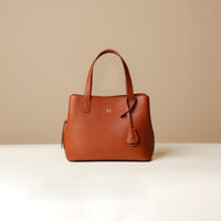 A brown leather handbag with a water-resistant fabric interior, featuring a top handle and a zipper closure.