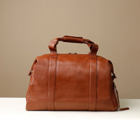 Back View of A brown leather duffle bag.
