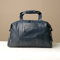 A navy blue leather duffle bag with two handles and a zippered compartment on the front side.