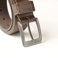 Close‑up of dotted leather texture and buckle detail on brown belt