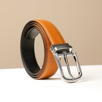 A brown leather belt with a silver buckle on a light background.