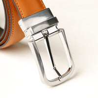 Close‑up of stitching detail on tan leather belt and buckle