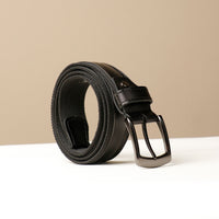 A coiled black canvas belt with a leather buckle, displayed against a neutral background.