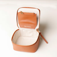 upper view of a small leather Danilos Jewelry Organizer Anushka in brown with a gold zipper and a brown pocket on a white background