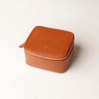 front view of a small leather Danilos Jewelry Organizer Anushka in brown with embossed gold text on a white background