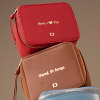 Three small Danilos leather jewelry organizers, Anushka with embossed text on a brown background