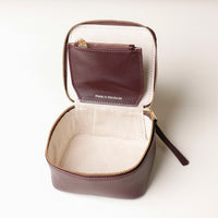 upper view of an open small leather Danilos Jewelry Organizer Anushka in dark brown with embossed gold text on a white background