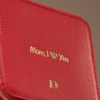 Close-up view of a small leather Danilos Jewelry Organizer Anushka in red with embossed gold text on a white background