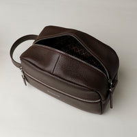 Open view of a brown toiletry bag 2014 with a silver zipper closure and a handle, with visible brand Danilos, placed against a neutral background. Upper view. 