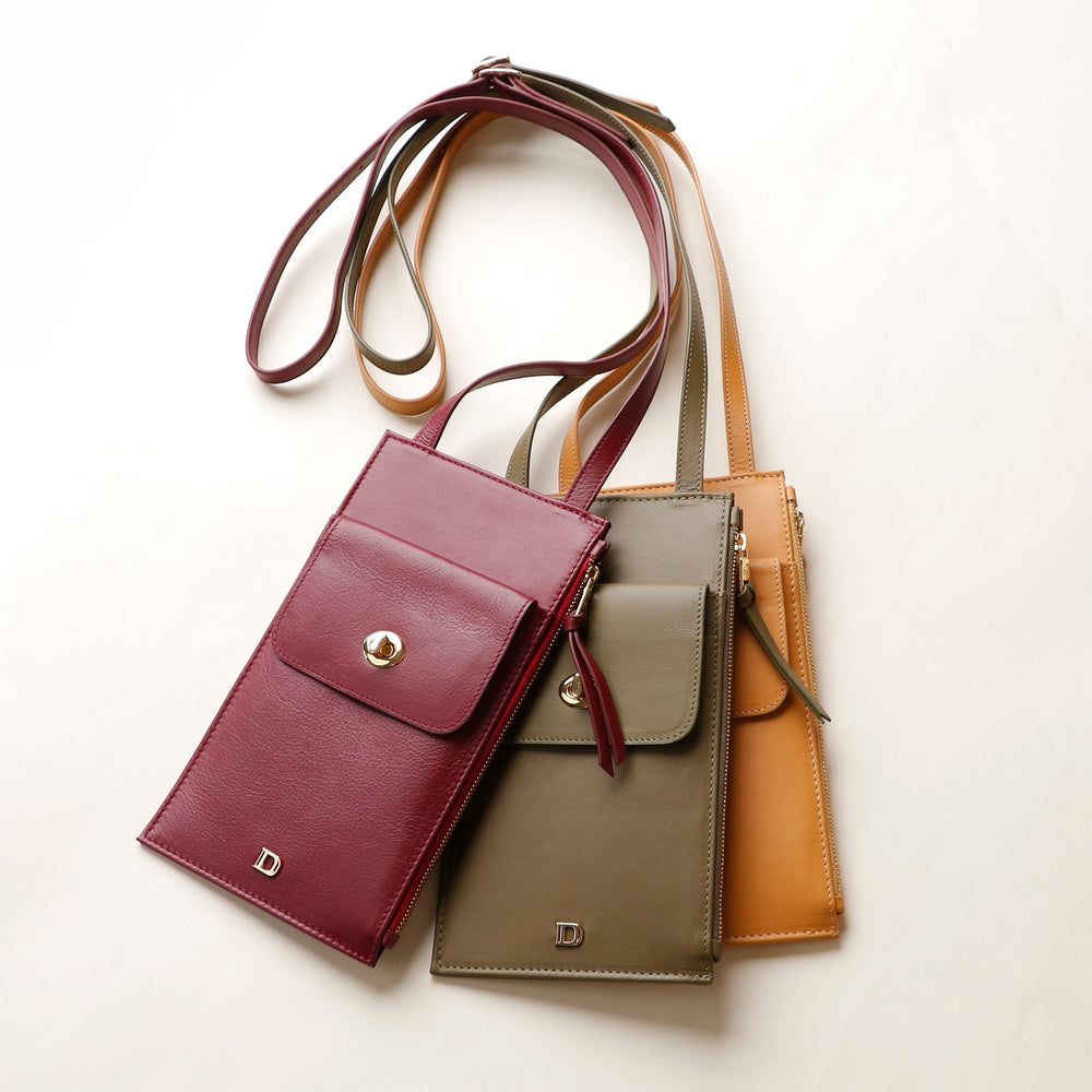 Three leather handbags in different colors on a light background
