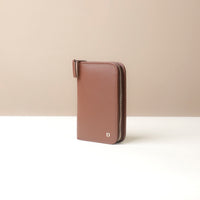 Brown wallet with a zipper on a beige background