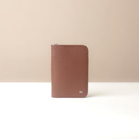 Brown leather wallet on a beige background