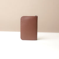 Brown leather wallet on a beige background