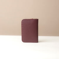 Purple leather wallet on a white surface with a beige background
