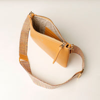 Yellow handbag with a mesh strap on a light background