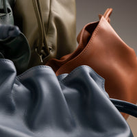 ruched Stack of Danilo’s Sassy Satchel bags in terracotta, navy, olive, and forest green – ruched leather drawstring purses handcrafted in premium nappa leather
