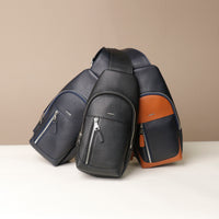 Front view of three Danilos leather sling packs Andres bags with silver zippers on a beige background
