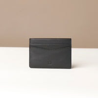 A black leather card holder with the letter 'P' embossed on the bottom right.