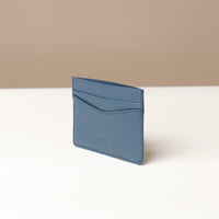 Blue cardholder on a white surface with a beige background