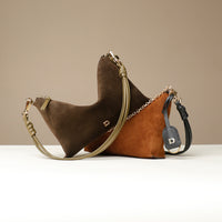 Two brown handbags with gold chains on a beige background