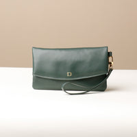 Front view of a green leather Karelia Clutch Danilos with a visible hand strap over a white and beige background