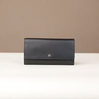 front view of a danilos clucth versaviva in black leather in a beige background