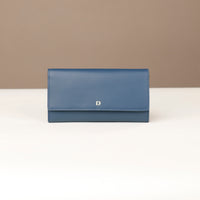 front view of a danilos clucth versaviva in navy blue leather in a beige background