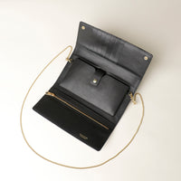 opened Black Danilos clutch with gold chain strap on a light beige background