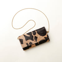 Clutch Danilos bag with cow print pattern on a white background