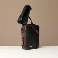 side view of a danilos black and brown crossbody dylan bag over a beige background